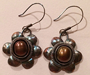 Catherine recently finished these earrings, which are based on a design she saw on an ancient gold bracelet. They are made of sterling silver sheet metal, coiled sterling wire and brown pearls.